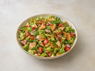 Tazón grande de fattoush libanés con pan pita crujiente, tomates, pepino, rábanos, hierbas y zumaque