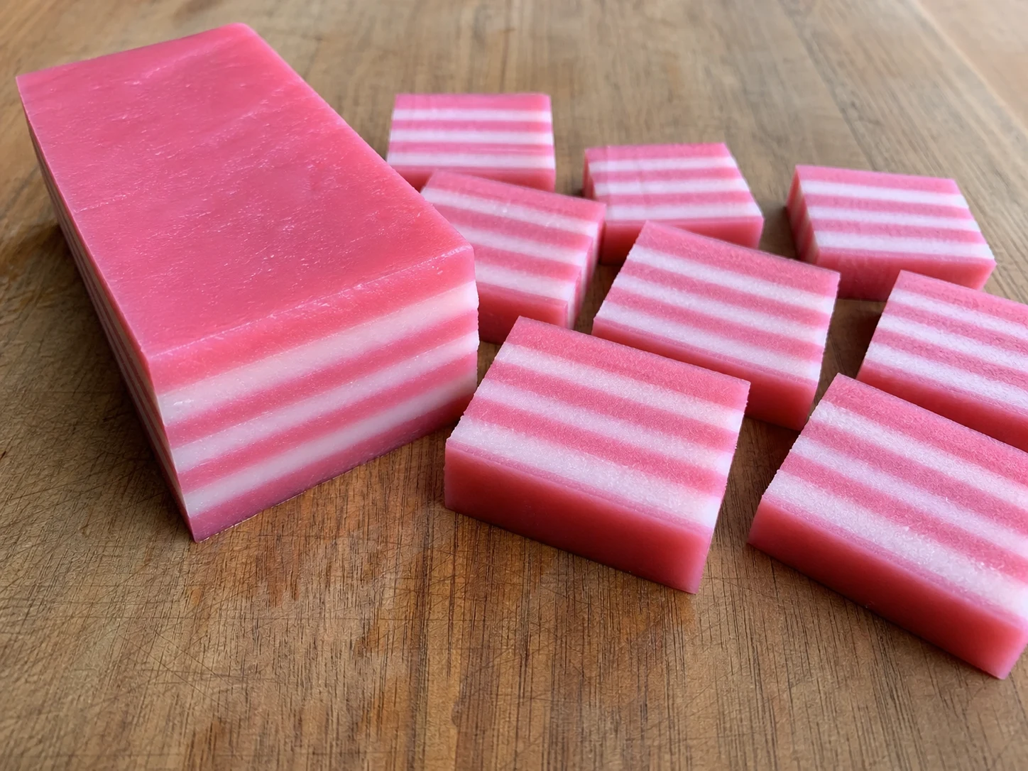 Unmolded Malaysian kuih lapis cut to reveal alternating pink and white layers