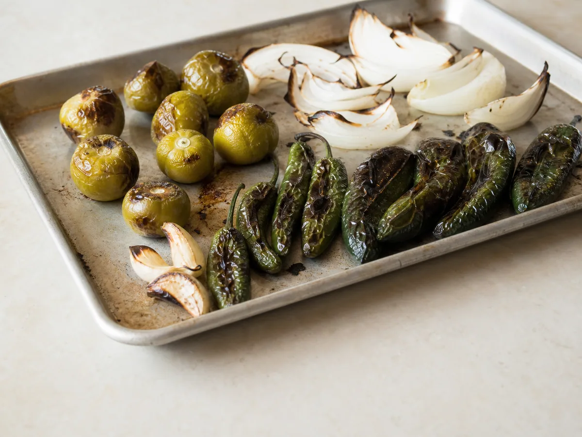 Tomatillos, pimentas poblano e serrano, cebola e alho tostados no grill para o pozole verde de frango