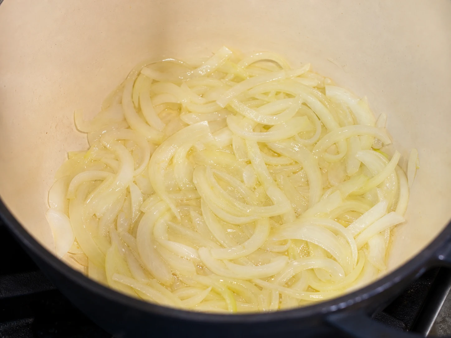 Cebola-branca em fatias finas, macia no azeite, com bordas levemente douradas