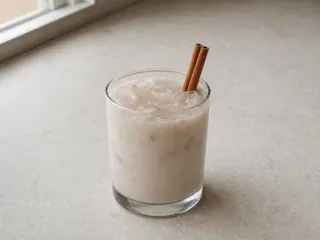 Vaso de horchata mexicana de canela, de color claro, servido con hielo