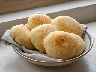 Pila de panes batbout marroquíes esponjados con manchas marrones tostadas
