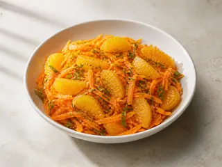 Tazón poco profundo de ensalada marroquí de zanahoria y naranja con menta fresca