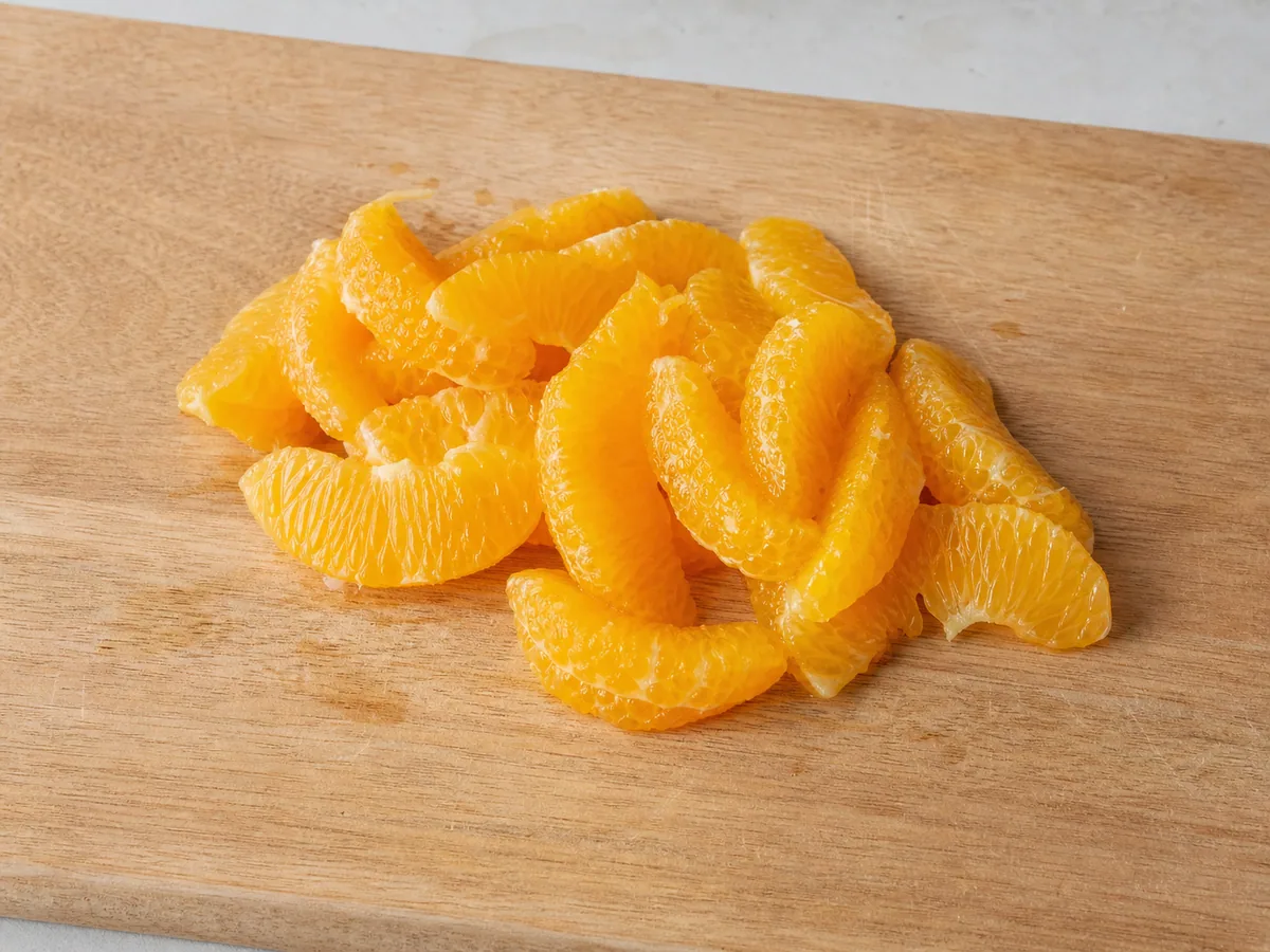 Gomos de laranja e suco recolhido, preparados para a salada marroquina de cenoura e laranja