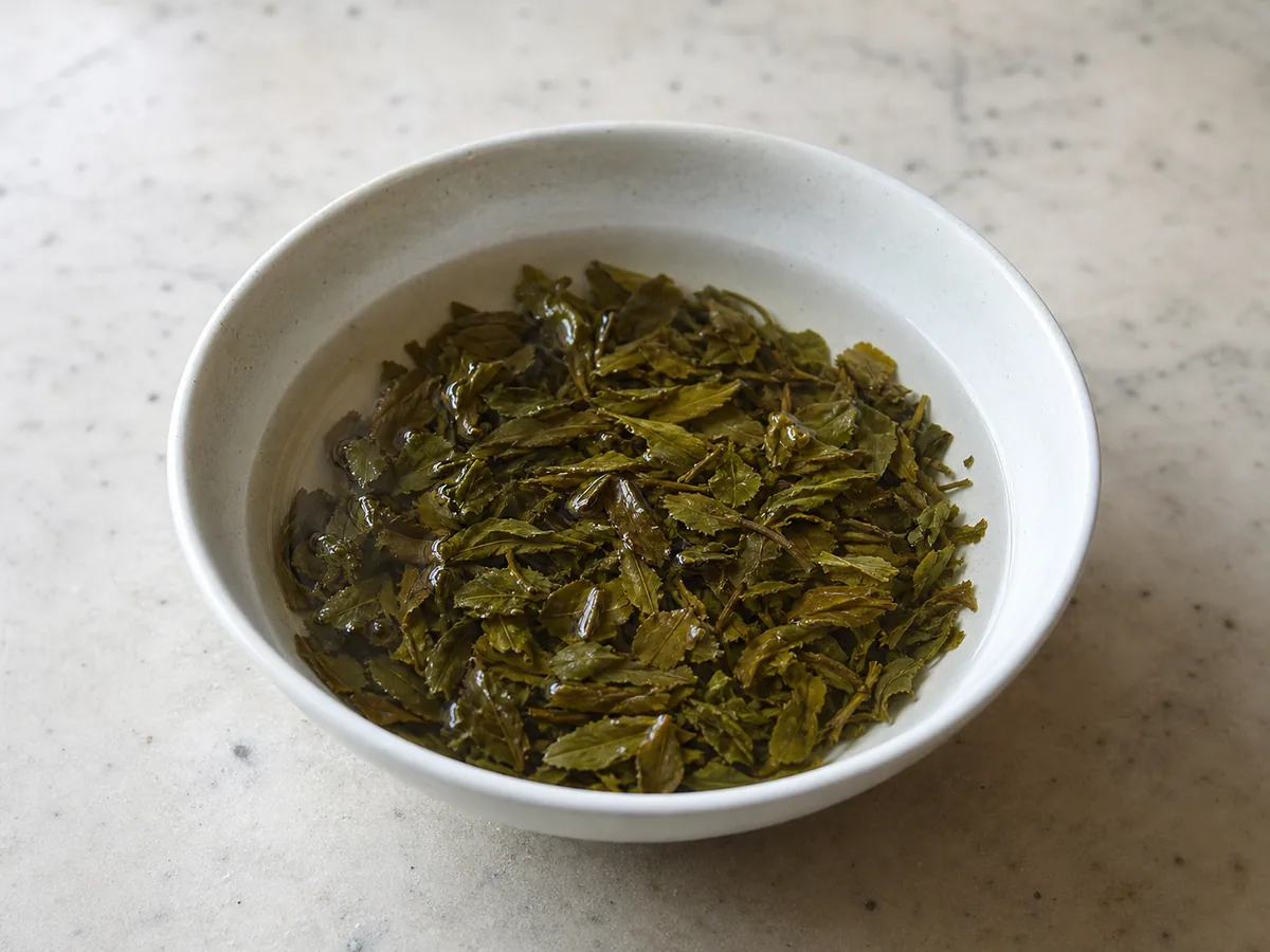 Folhas de chá verde gunpowder enxaguadas, mantidas em uma panela pequena para o chá marroquino de hortelã
