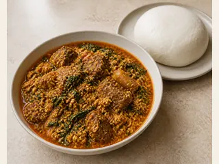 Tazón de sopa nigeriana de egusi con espinaca, carne de res y aceite de palma anaranjado rojizo
