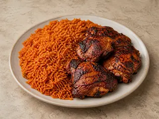 Arroz jollof nigeriano servido con muslos de pollo sazonados a la parrilla