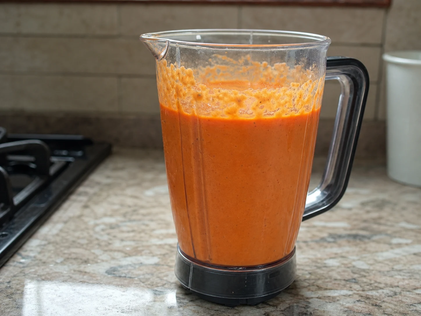 Massa lisa de moi moi laranja-avermelhada no copo do liquidificador