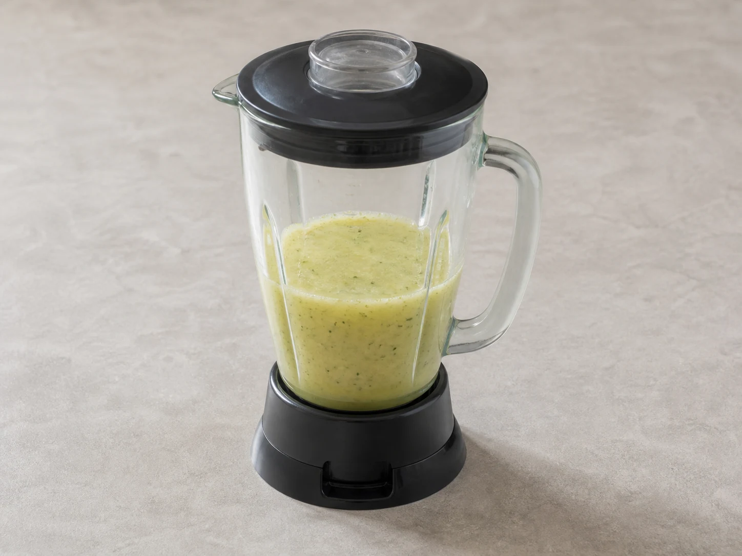 Pale yellow pineapple mint agua fresca blended smooth with tiny green mint flecks