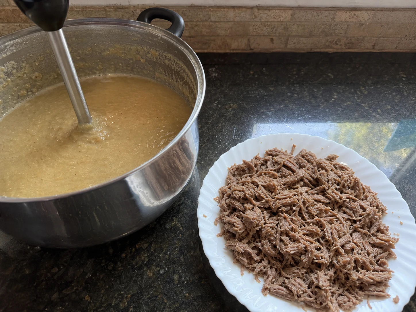 Masala-coated shredded beef folded into blended grains and lentils for Pakistani haleem