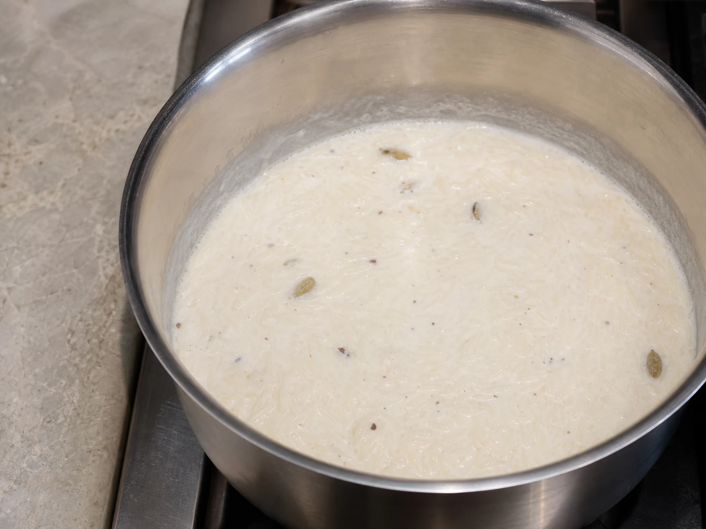 Very soft basmati rice simmering in loose cardamom milk for Pakistani cardamom rice kheer