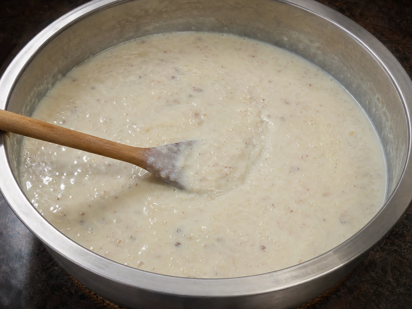Glossy Pakistani cardamom rice kheer leaving a brief spoon trail after sweetening