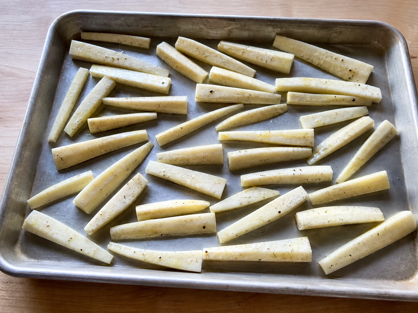 Even parsnip batons with any woody cores removed, coated with oil and seasoning on a rimmed baking sheet before roasting