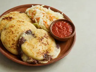 Salvadoran cheese and bean pupusas served with curtido and salsa roja