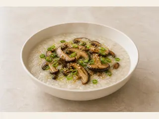 Tigela de mingau salgado de cogumelos coberto com cebolinha e sementes de gergelim