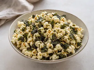 Bowl of seaweed popcorn speckled with white and black sesame seeds
