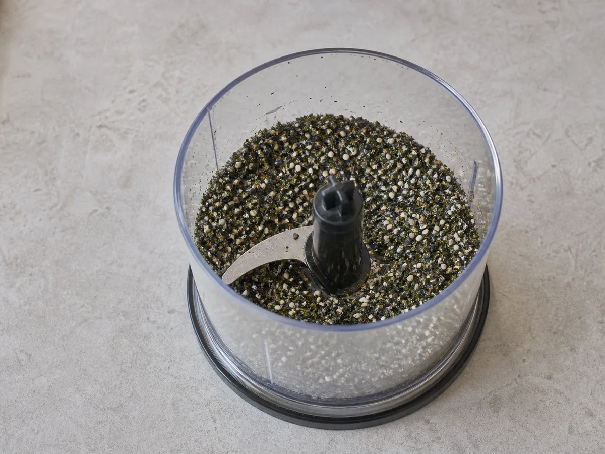 Tempero grosso de nori e gergelim, com flocos verdes finos e sementes inteiras visíveis