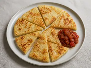Tortitas escocesas de papa doradas servidas con relish de tomate con trozos