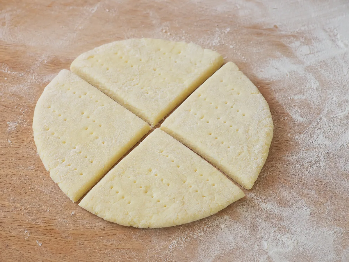 Dos discos finos de masa de papa pinchados y cortados en ocho triángulos de tortita