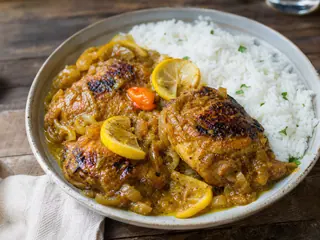Senegalese chicken yassa with golden onion sauce served beside white rice