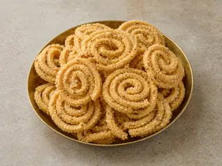 Pale-golden ridged murukku spirals in a simple bowl