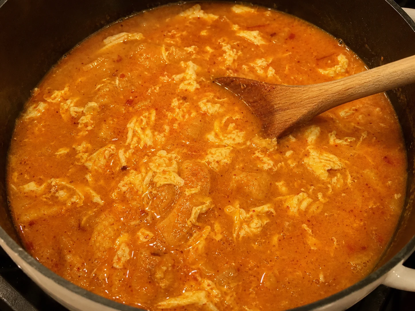 Fully cooked opaque egg ribbons in Spanish garlic bread soup
