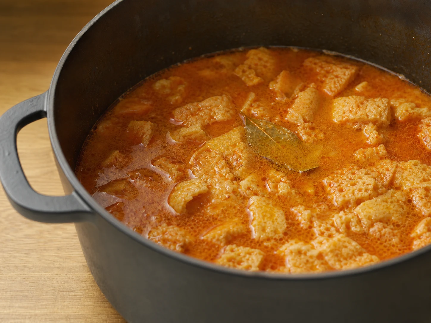 Spoon-soft bread in loose paprika broth for Spanish garlic bread soup