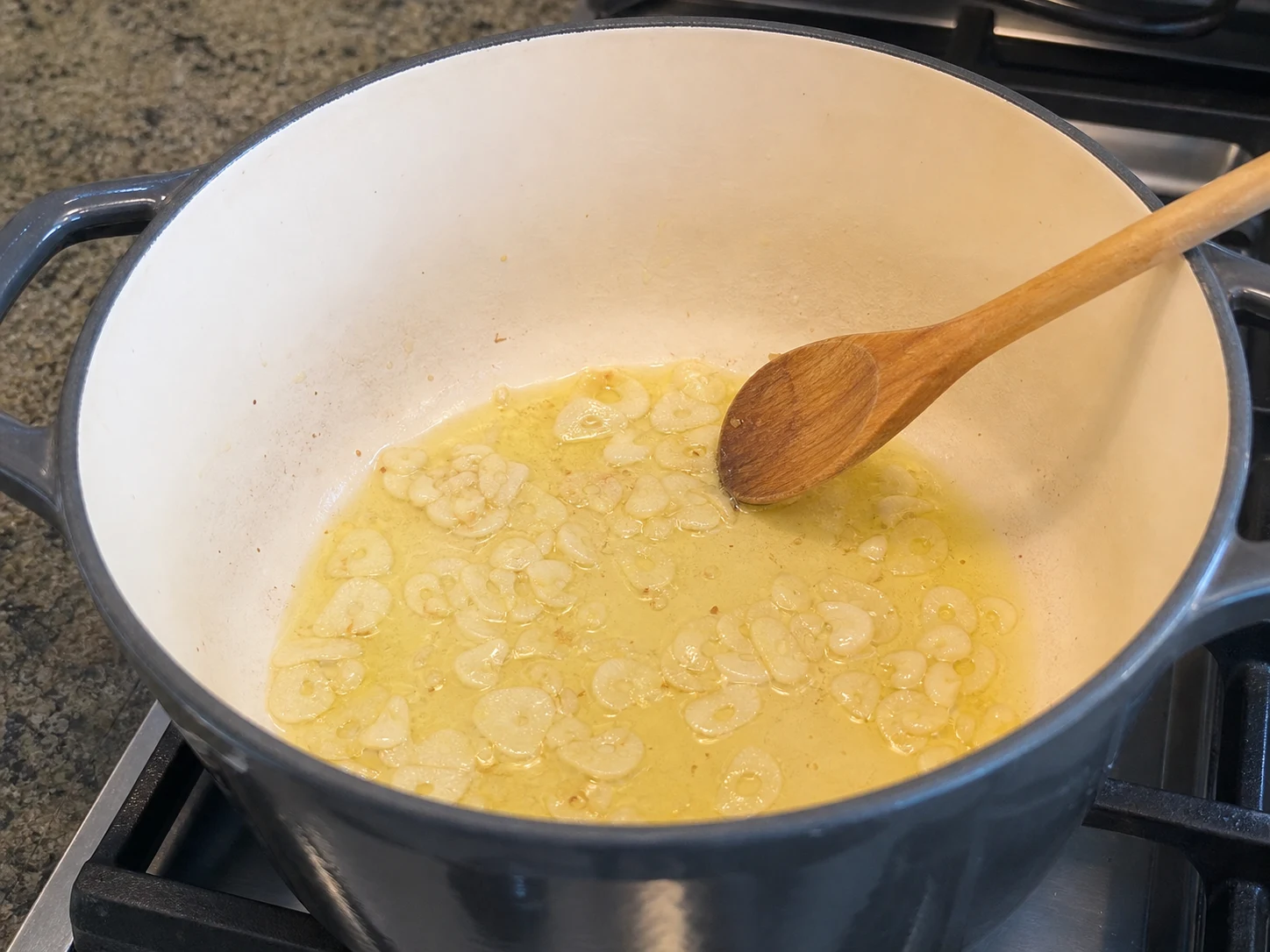 Pale-gold garlic slices softened in olive oil for Spanish garlic bread soup