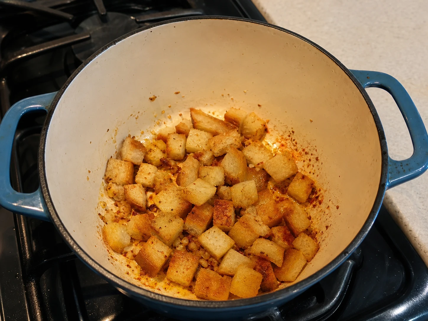 Lightly toasted bread coated with paprika and garlic oil for Spanish garlic bread soup