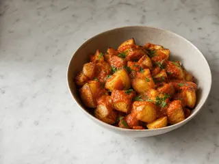 Patatas bravas espanholas com molho vermelho defumado e salsa