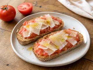 Torradas espanholas de café da manhã com tomate ralado e lascas de queijo Manchego
