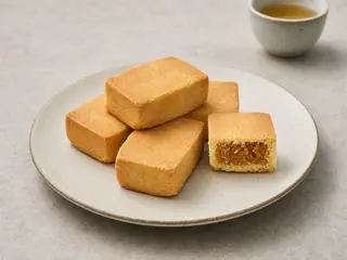 Pastelitos taiwaneses rectangulares de piña, uno abierto para mostrar el relleno fibroso