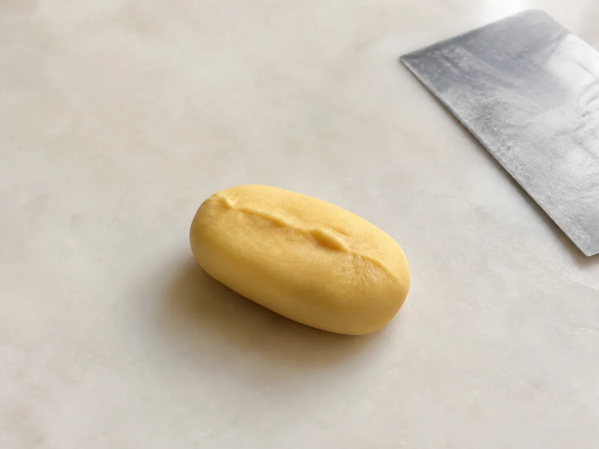 Pineapple filling fully enclosed in pastry dough with the seam pinched closed