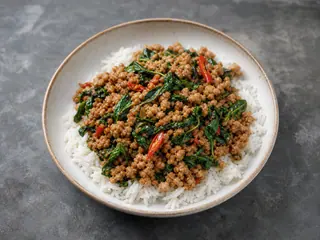 Pollo tailandés con albahaca santa sobre arroz jazmín con chiles rojos
