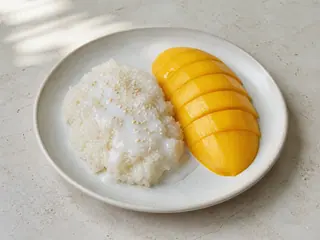 Arroz pegajoso tailandés con mango, salsa de coco y sésamo tostado