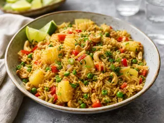 Arroz frito taileés con piña, anacardos, verduras, cebollines y limón