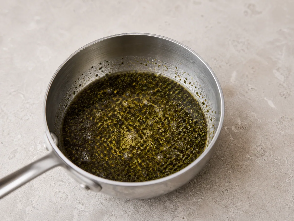 Aceite de pimentón y menta rojo ladrillo calentándose brevemente en una sartén pequeña para sopa turca de lentejas rojas