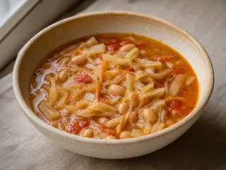 Bowl of Ukrainian cabbage and bean soup with potatoes, dill, and sour cream