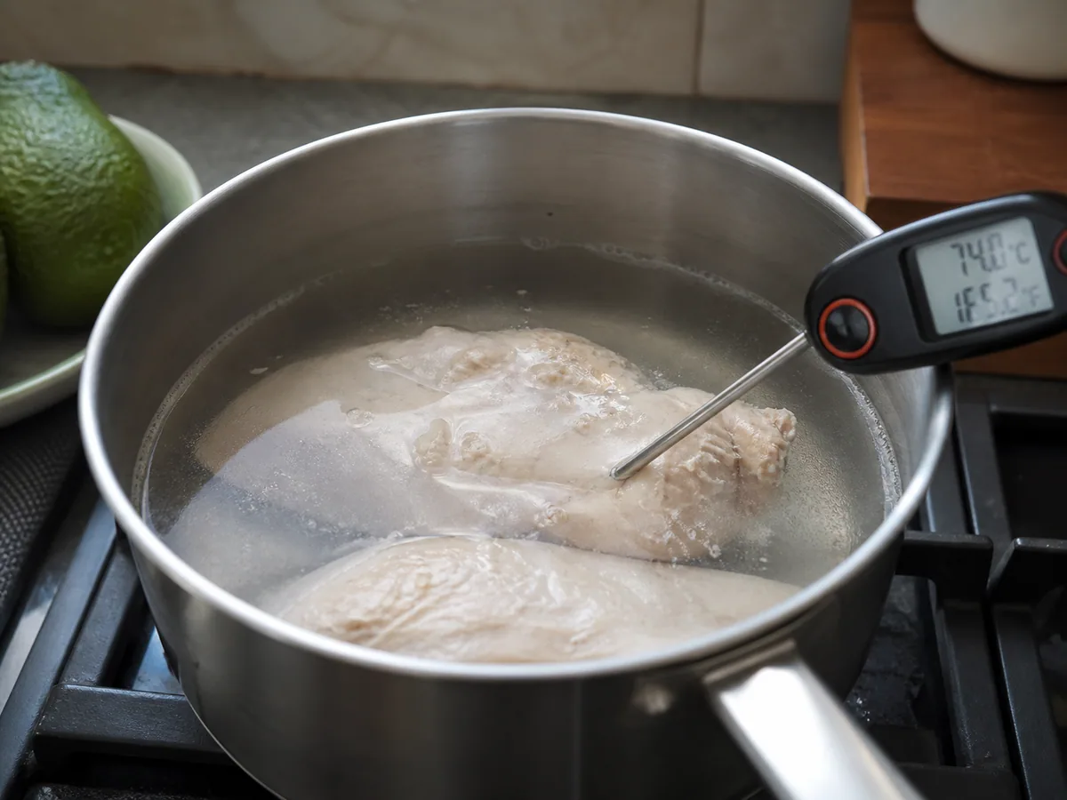 Peitos de frango totalmente cozidos, verificados com um termômetro culinário em uma panela