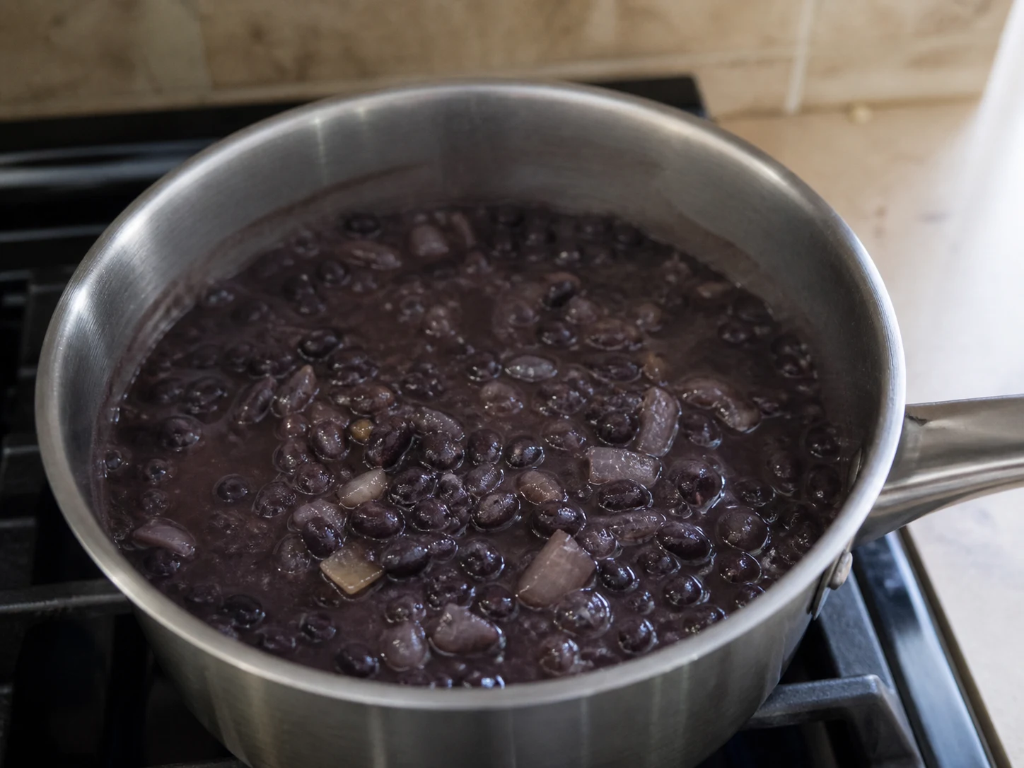 Frijoles negros cocidos hasta quedar brillantes y ligeramente espesos, con algunos frijoles machacados