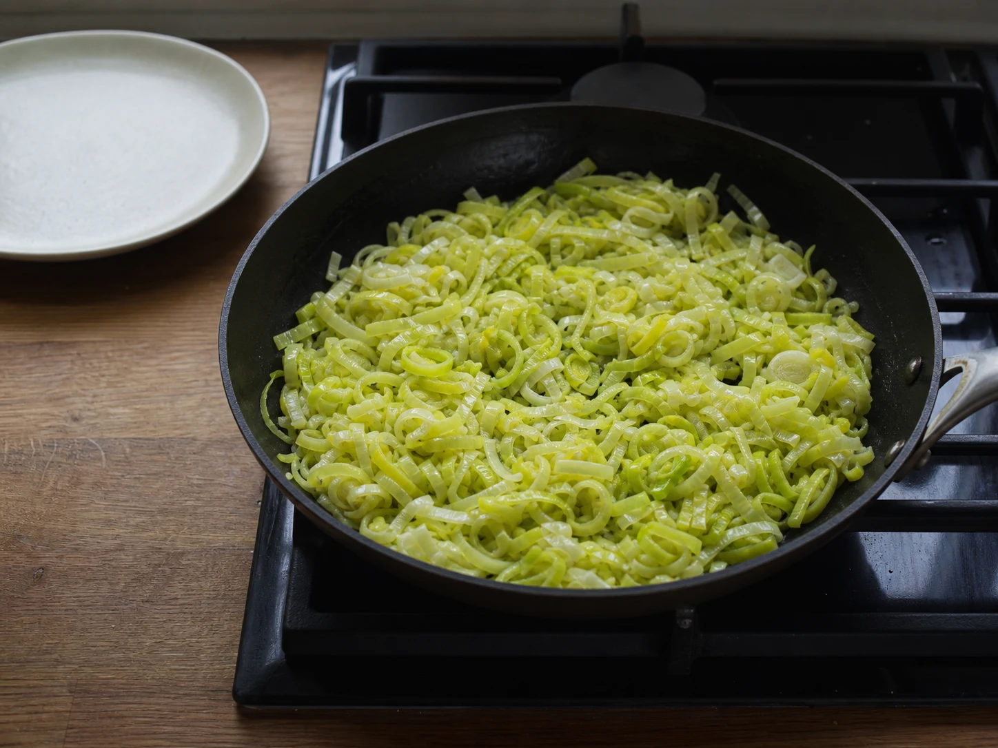 Soft dry sliced leeks in a skillet with no browning or standing liquid