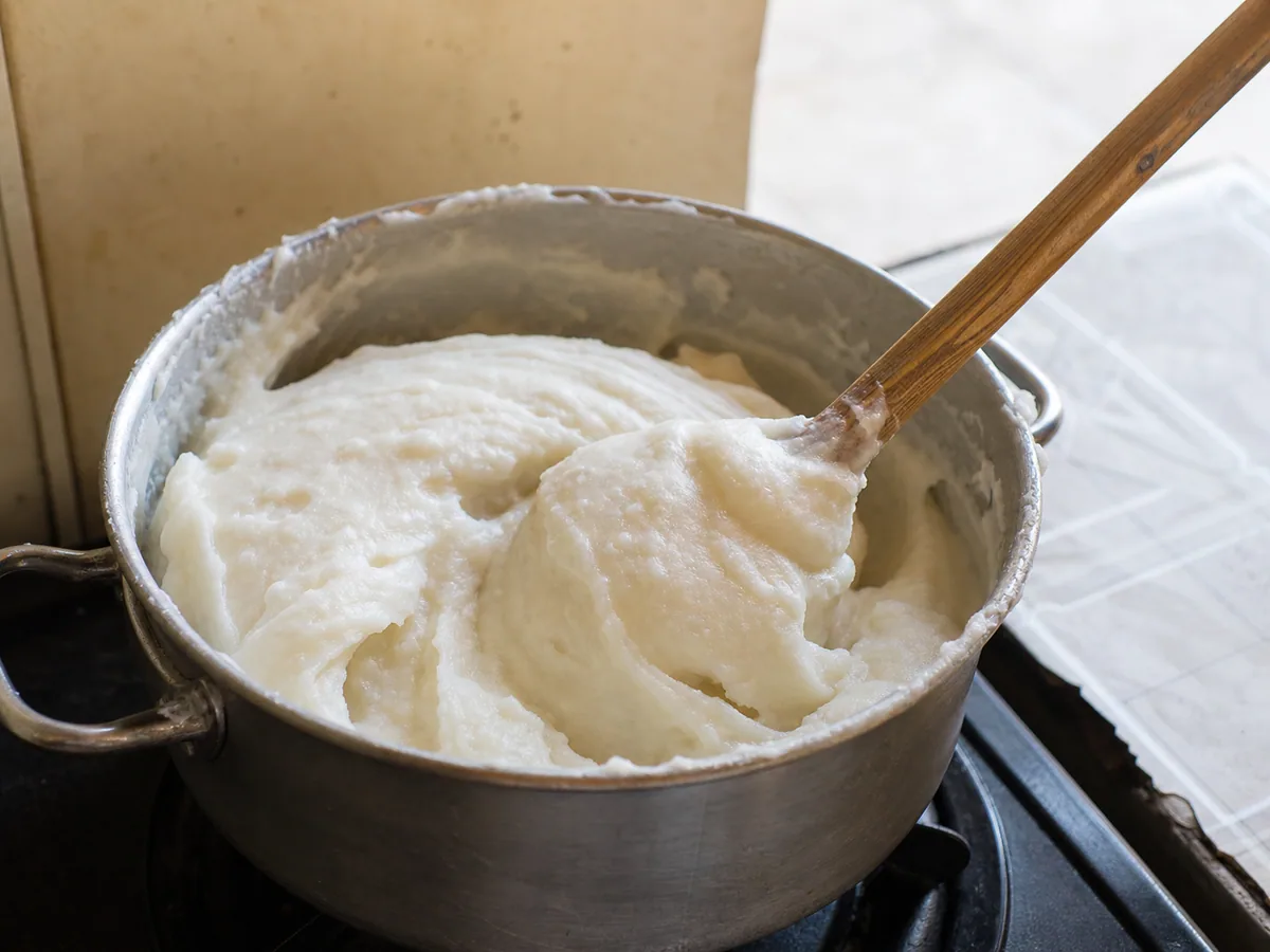Stiff white sadza pulling cleanly from the sides of a saucepan